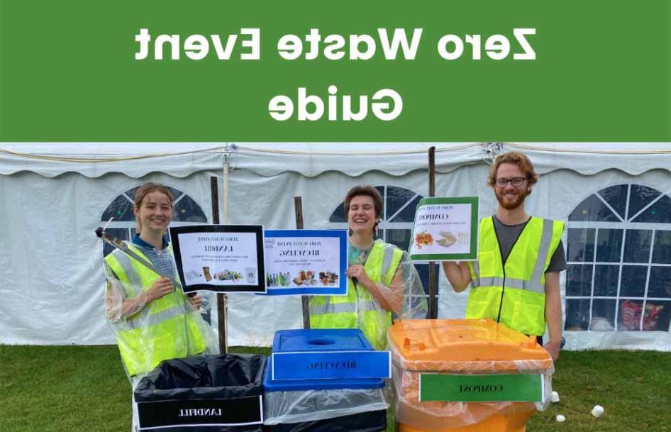 People stand with trash grabbers smiling by waste bins at an event.